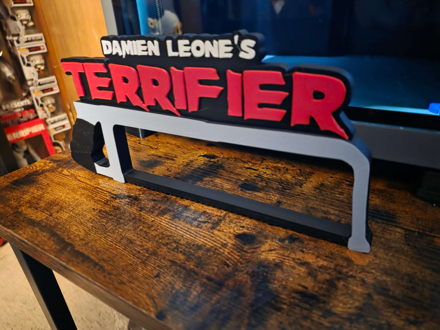 12-inch Terrifier art The Clown horror logo with black saw motif on black background