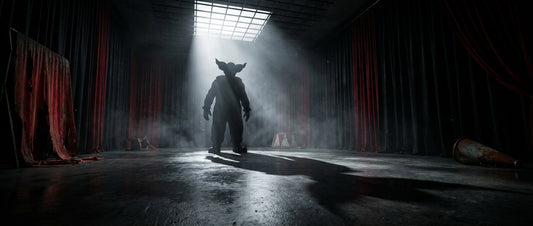 A towering life-size horror clown figure silhouetted in dramatic spotlight lighting against deep shadows in a cinematic, low-angle wide shot.
