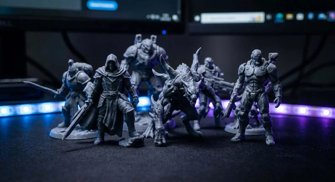 A collection of detailed 3D printed gaming character statues displayed on a dark desk under dramatic RGB lighting.