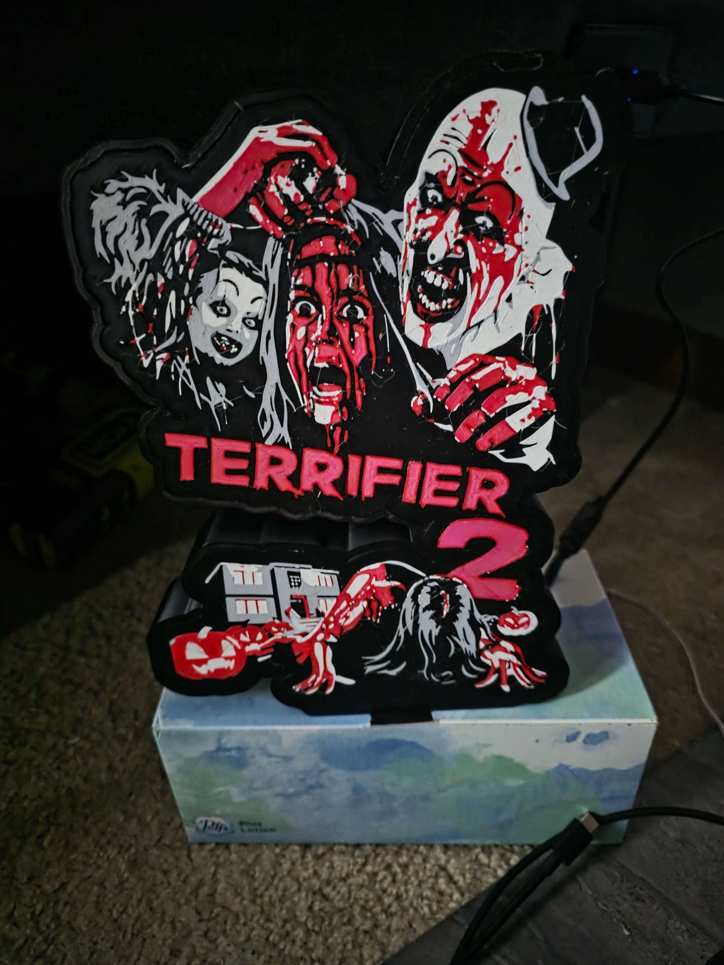 Terrifier 2 Art the Clown lightbox with red, white, grey, and black colors