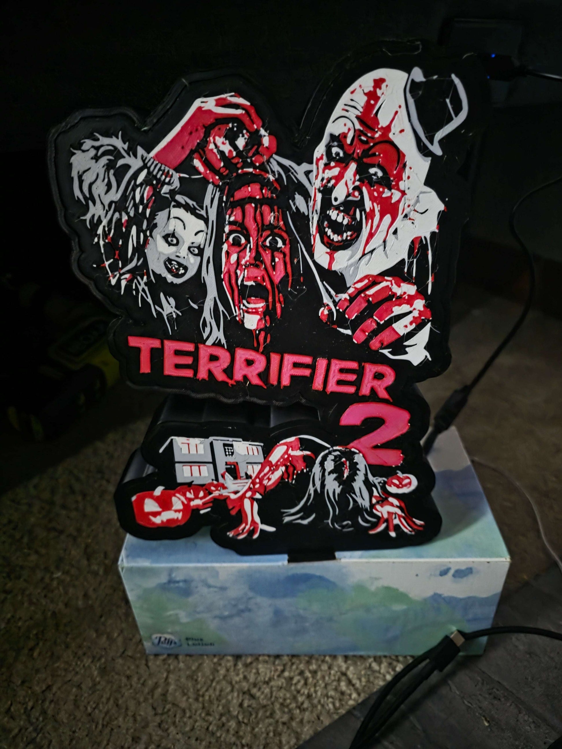 Terrifier 2 Art the Clown lightbox with red, white, grey, and black colors