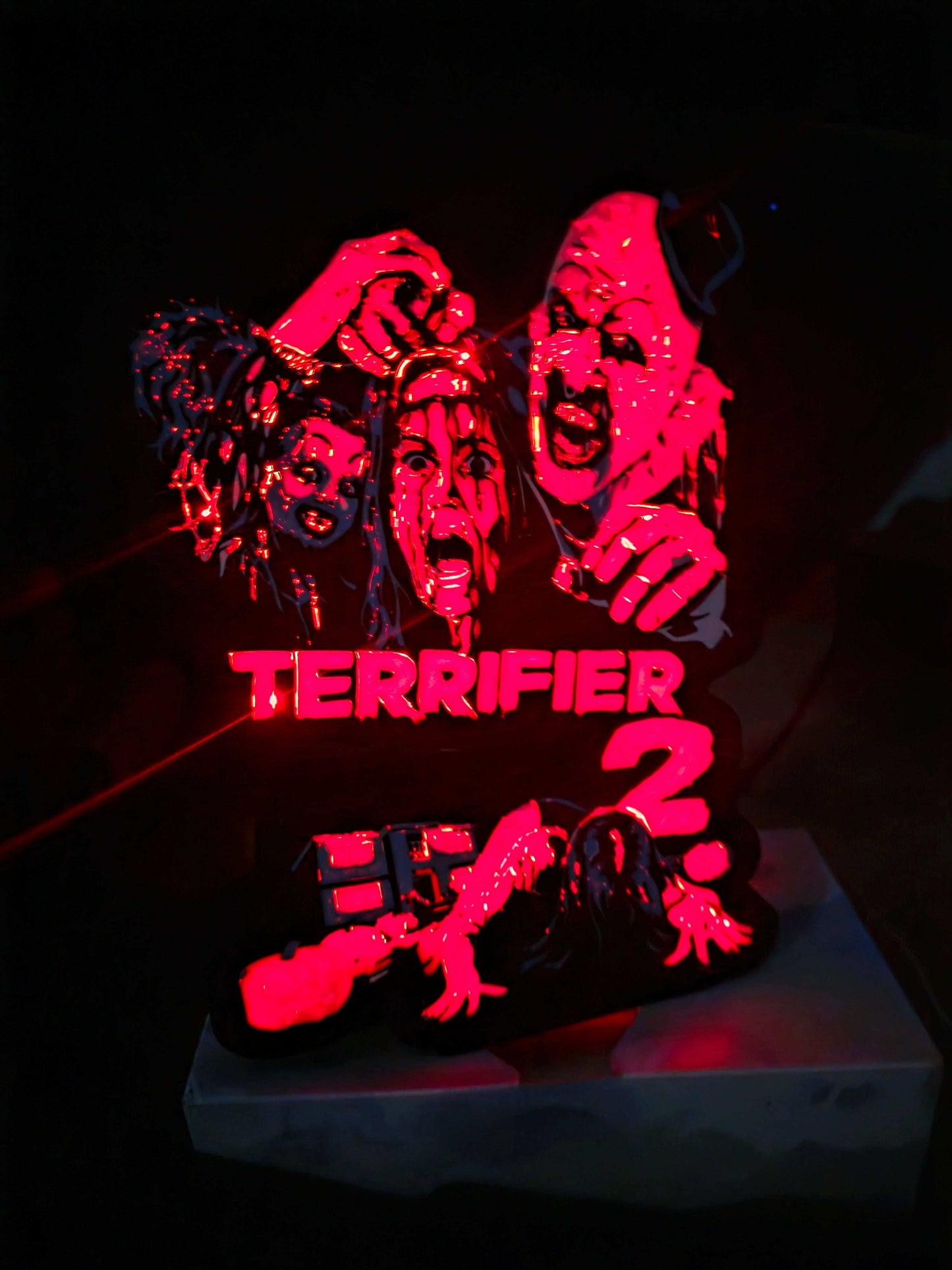 Terrifier 2 art clown lightbox with red blue white and black colors
