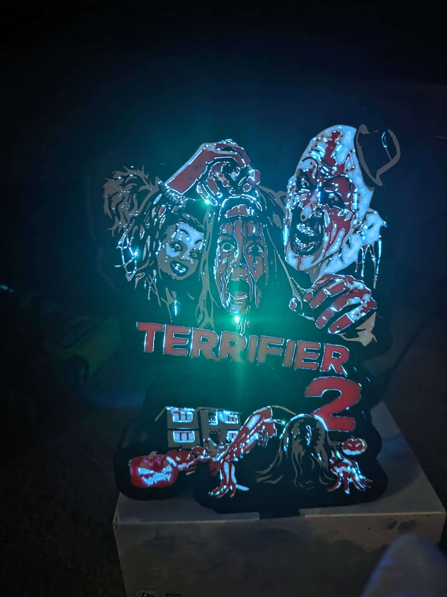 Terrifier 2 art lightbox featuring the clown in red, white, grey, and black colors