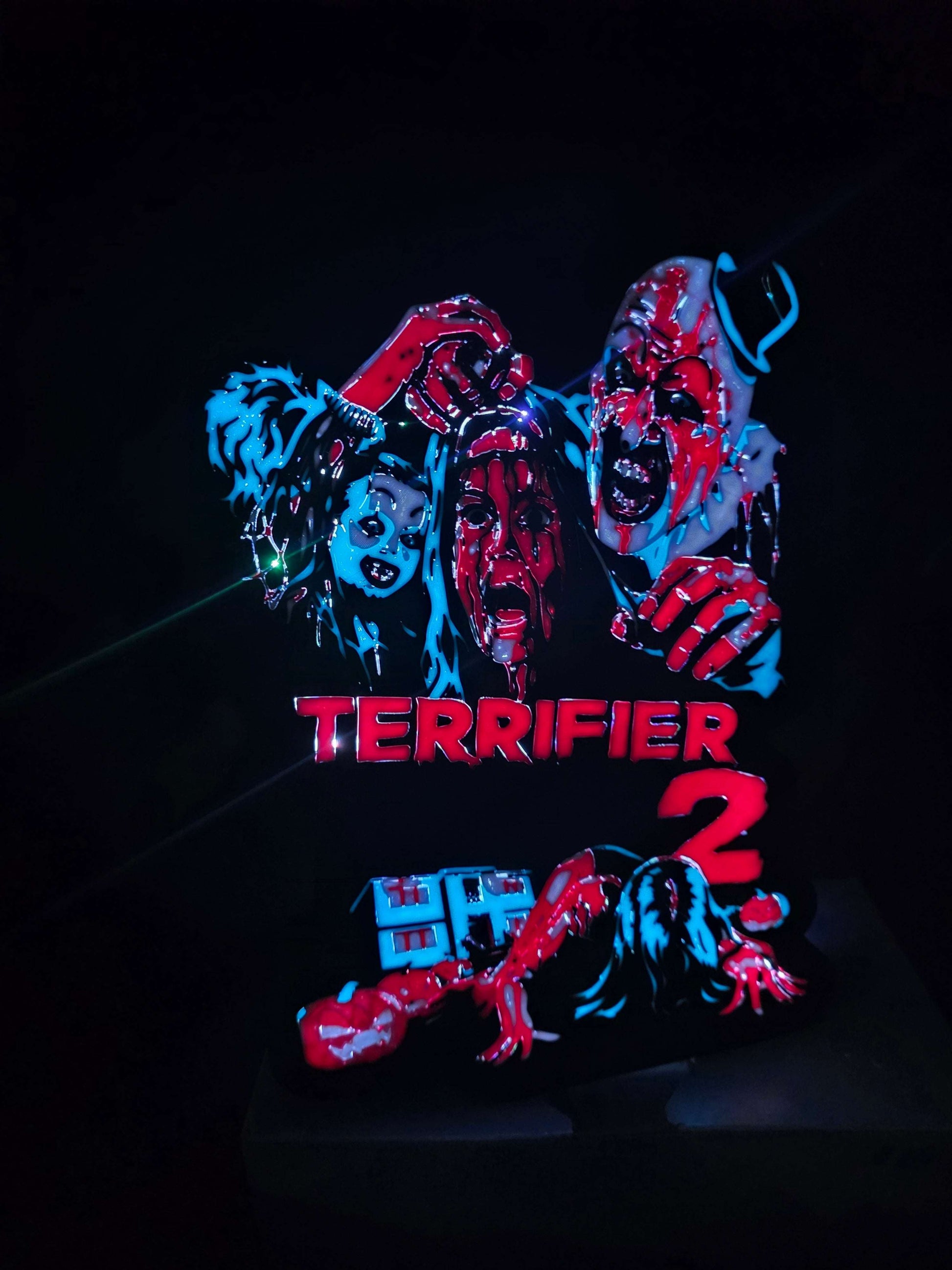 Terrifier 2 art of the clown in blue, red, white, and black lightbox