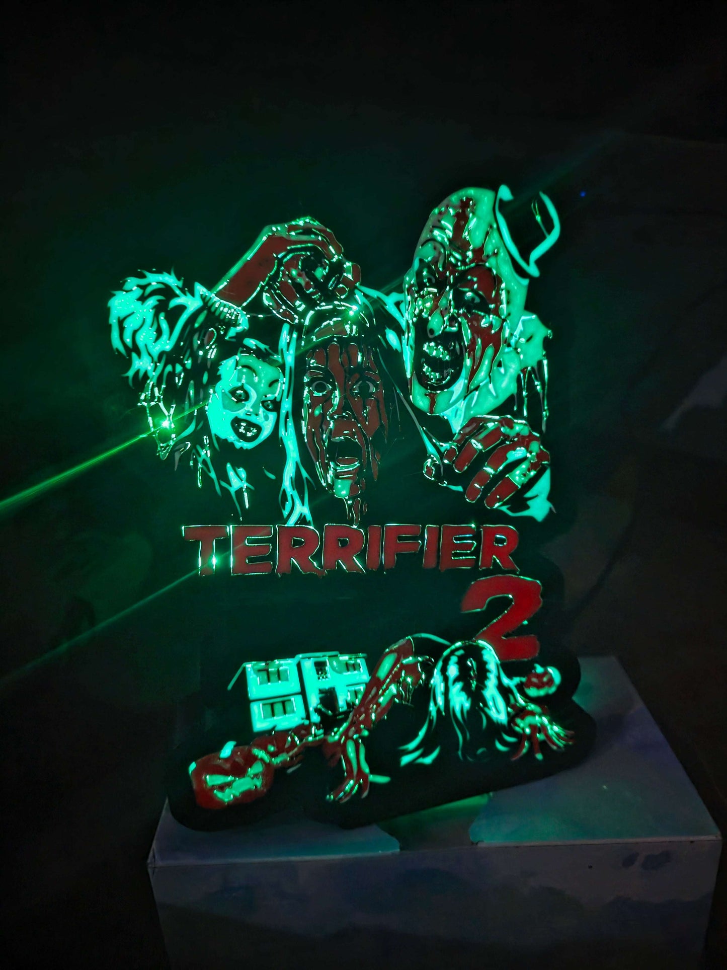 Terrifier 2 art featuring the clown in blue, red, white, and black lightbox