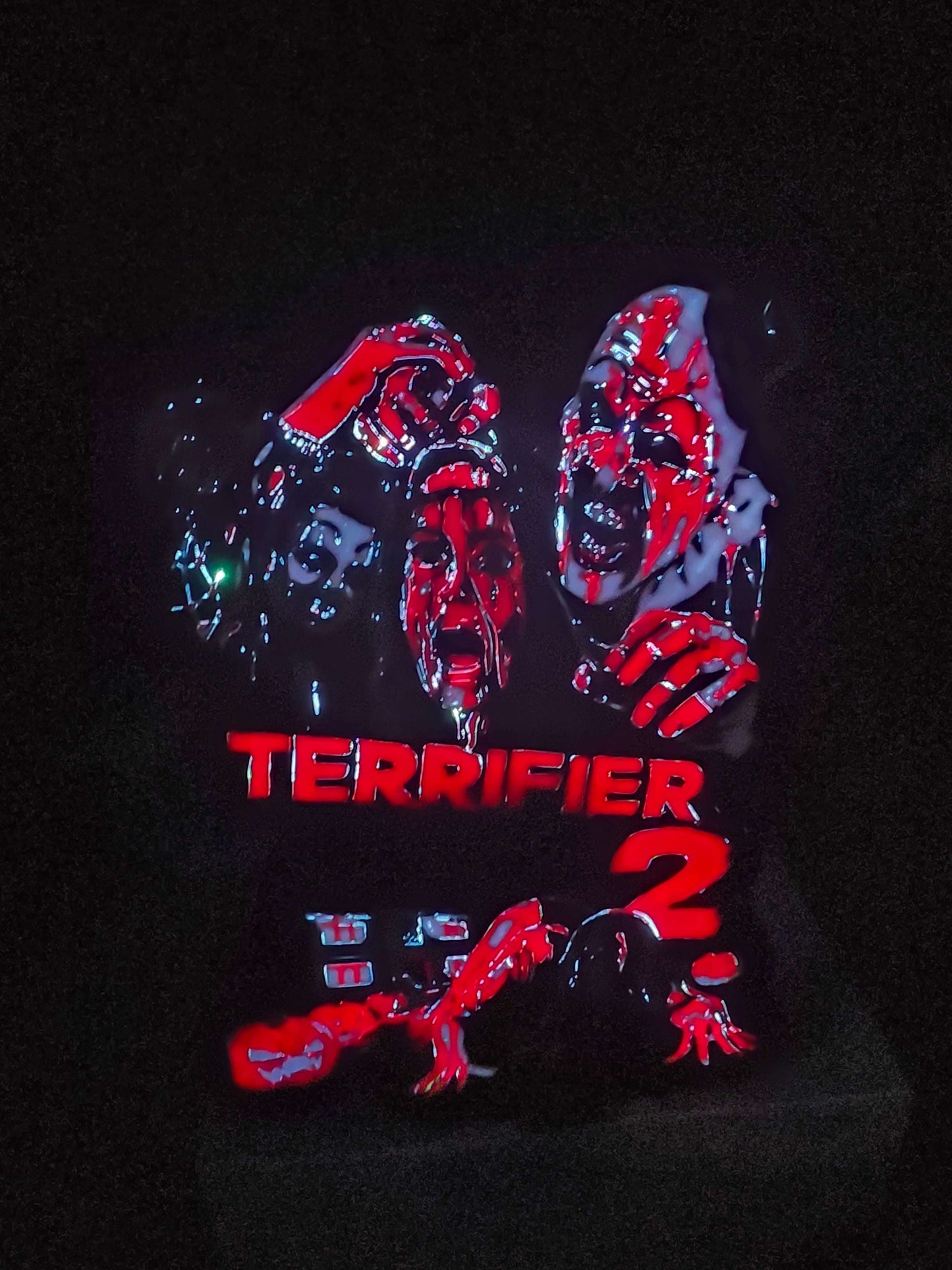 Terrifier 2 art featuring The Clown in red, white, grey, and black lightbox