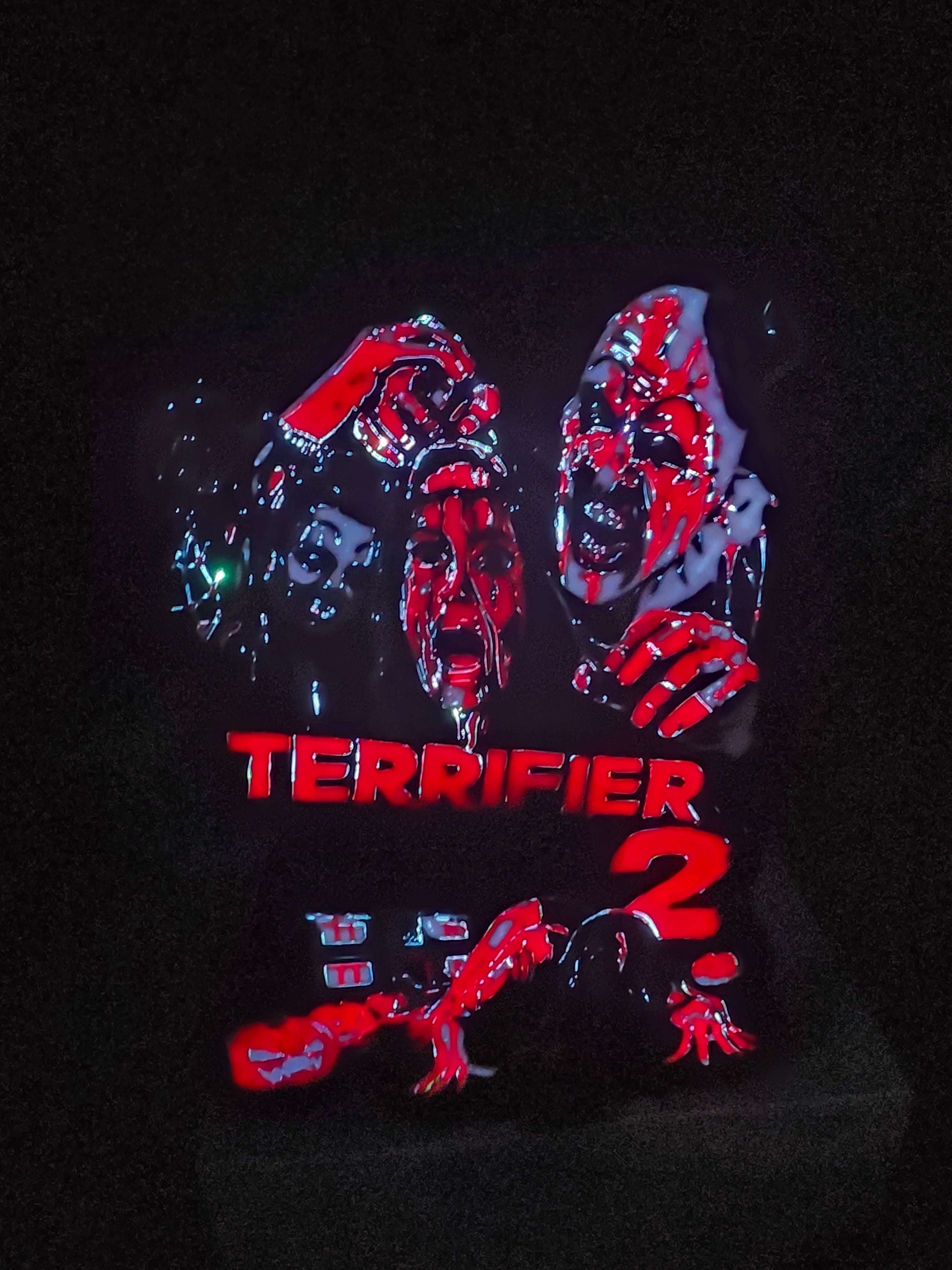 Terrifier 2 art featuring The Clown in red, white, grey, and black lightbox