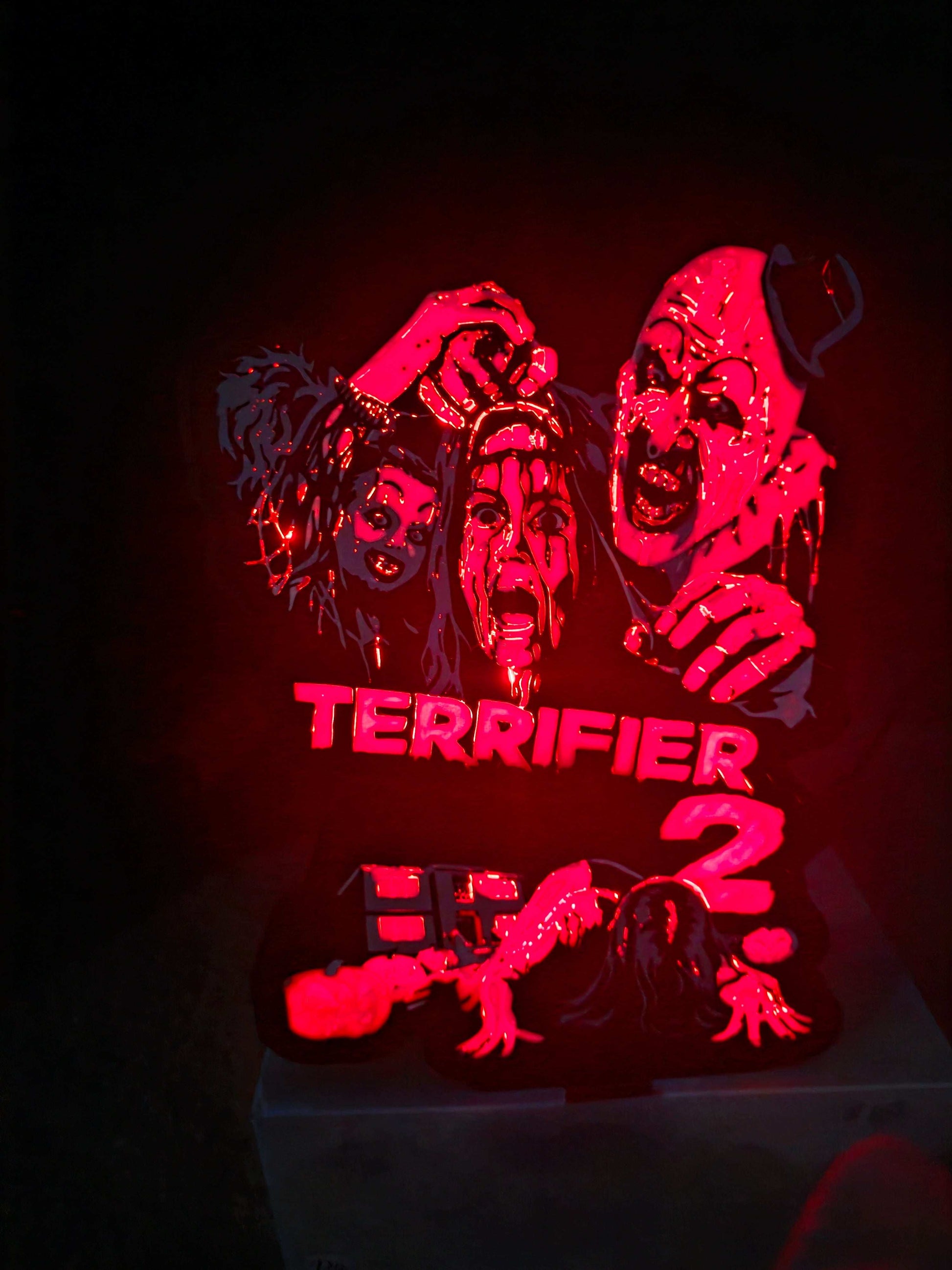 Terrifier 2 art of The Clown in red, white, grey, and black lightbox