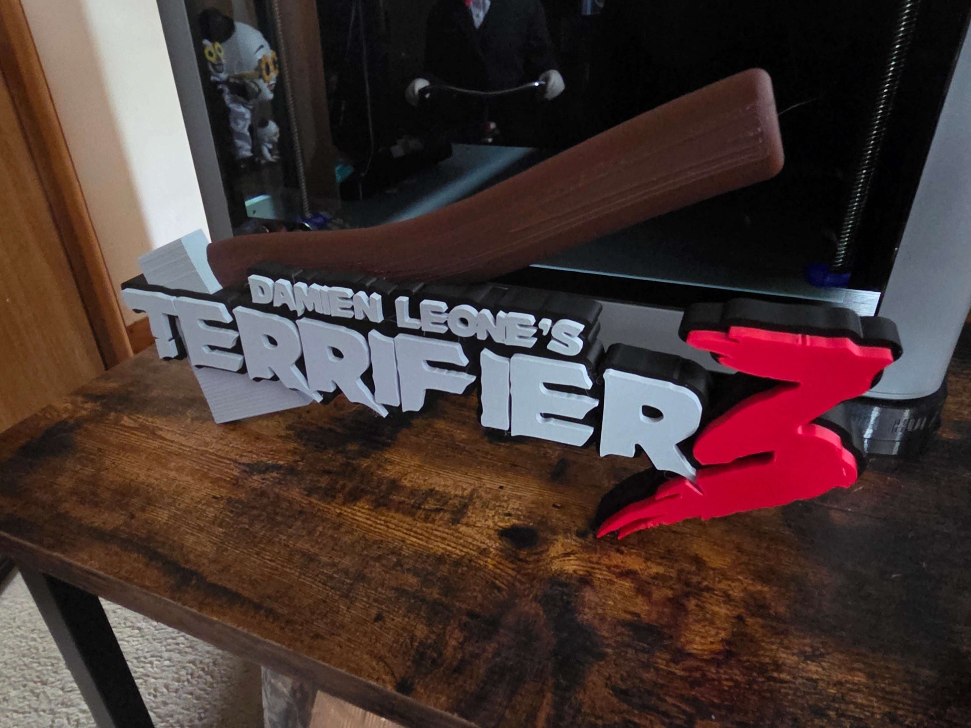 Terrifier 12-inch art piece featuring Art the Clown logo with grey axe design, horror decor collectible