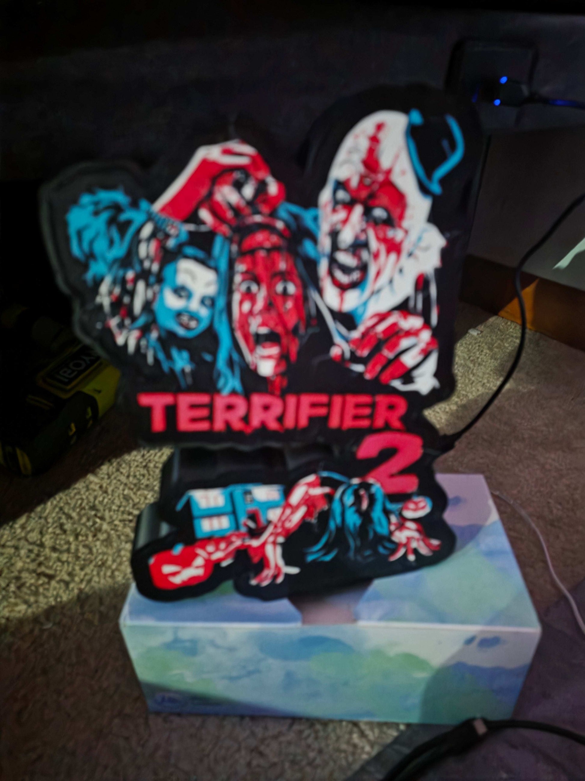 Terrifier 2 art of the clown in blue, red, white, and black lightbox