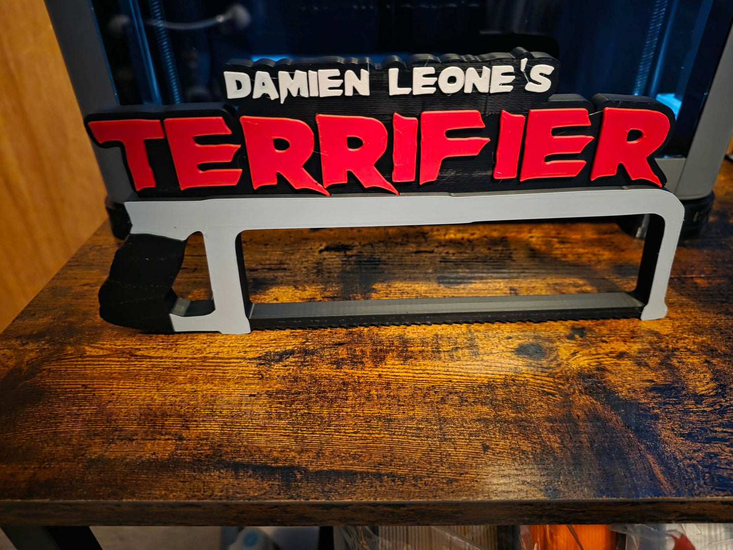 12-inch Terrifier art featuring The Clown horror logo with black saw motif for bold, high-impact decor