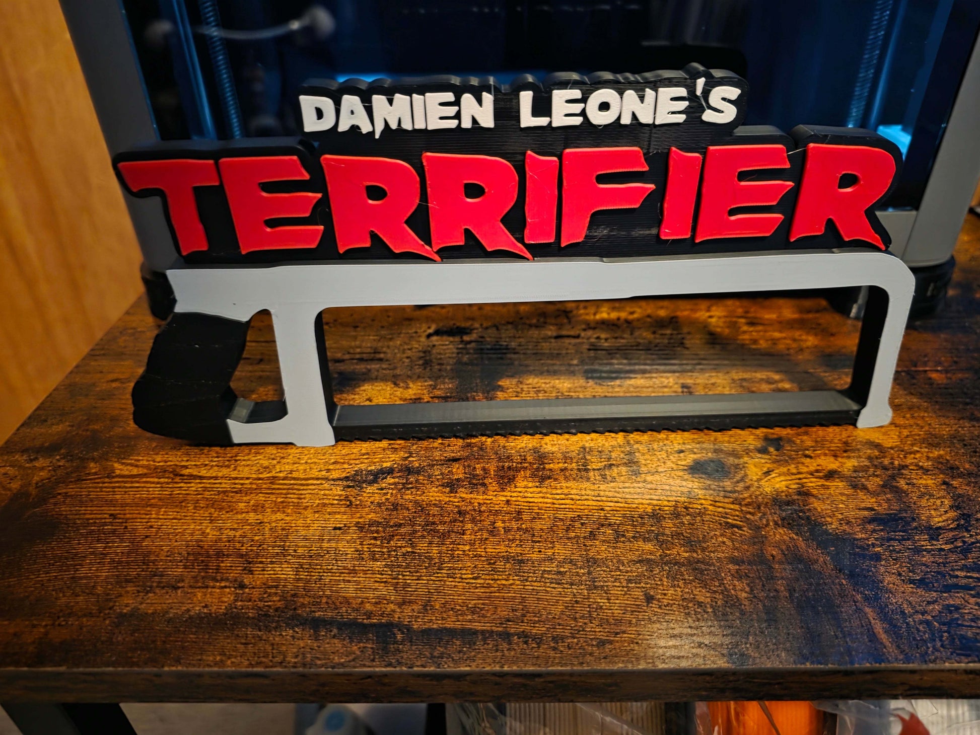 12-inch Terrifier art featuring The Clown horror logo with black saw motif for bold, high-impact decor